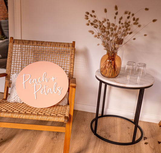 Bunny tails in mustard glass jar on table next styled next to a chair