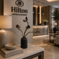 Hilton Hotels & Resorts logo in a luxurious hotel lobby with decor elements.