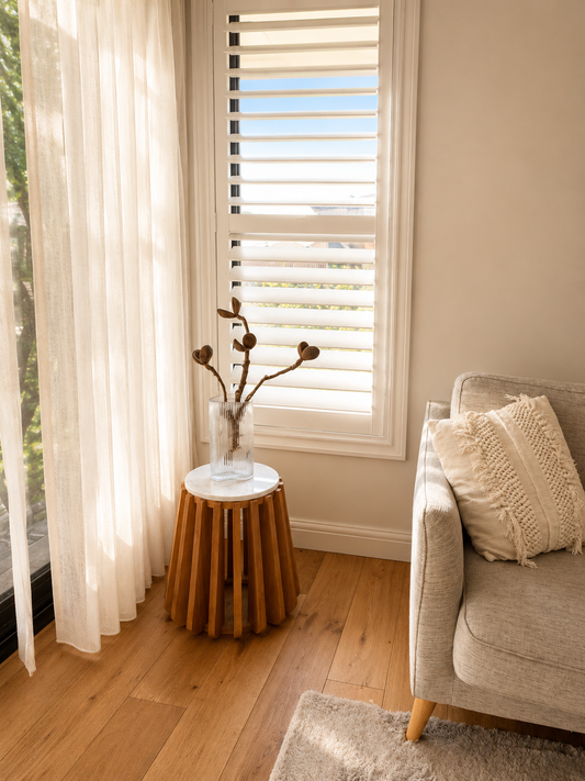 Living room with a couch, small table, and window with blinds