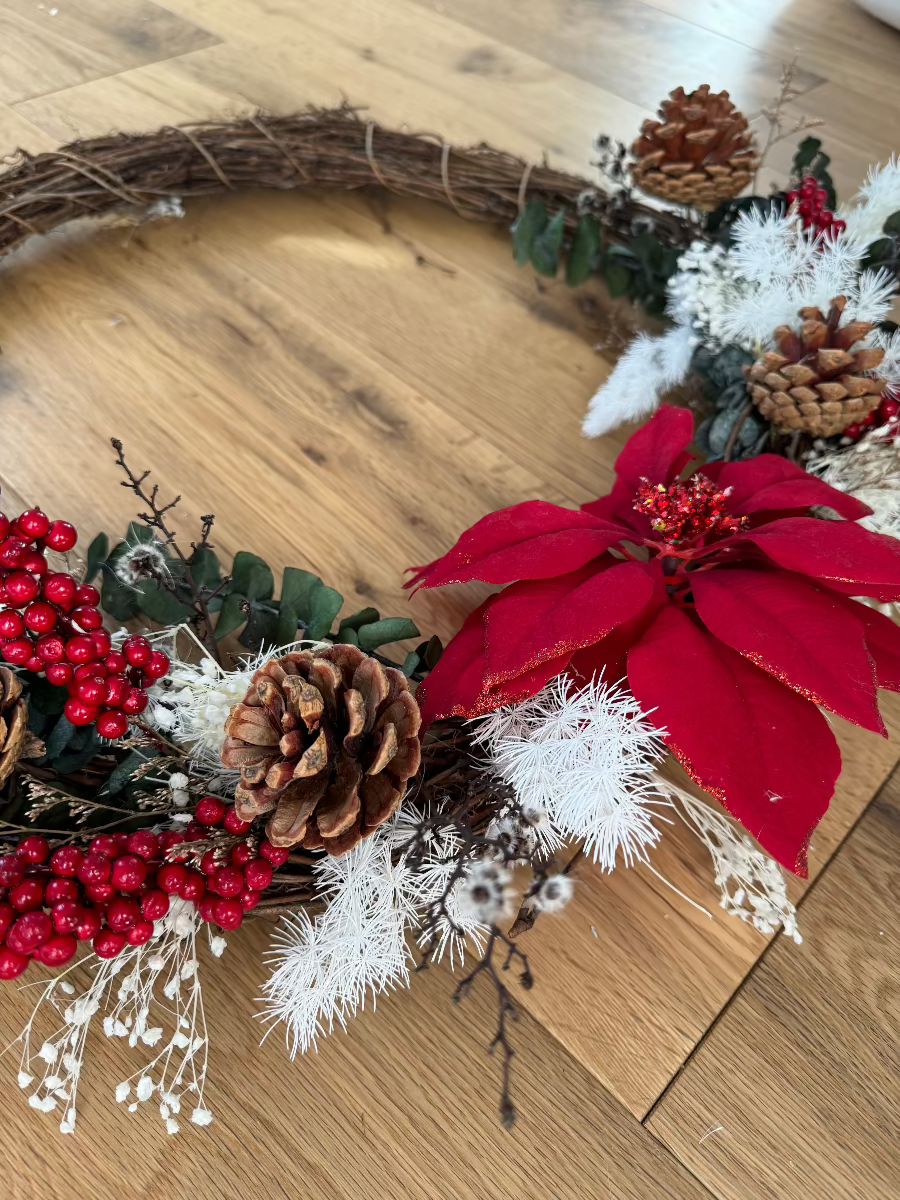 wreath with pine cones on wooden floor