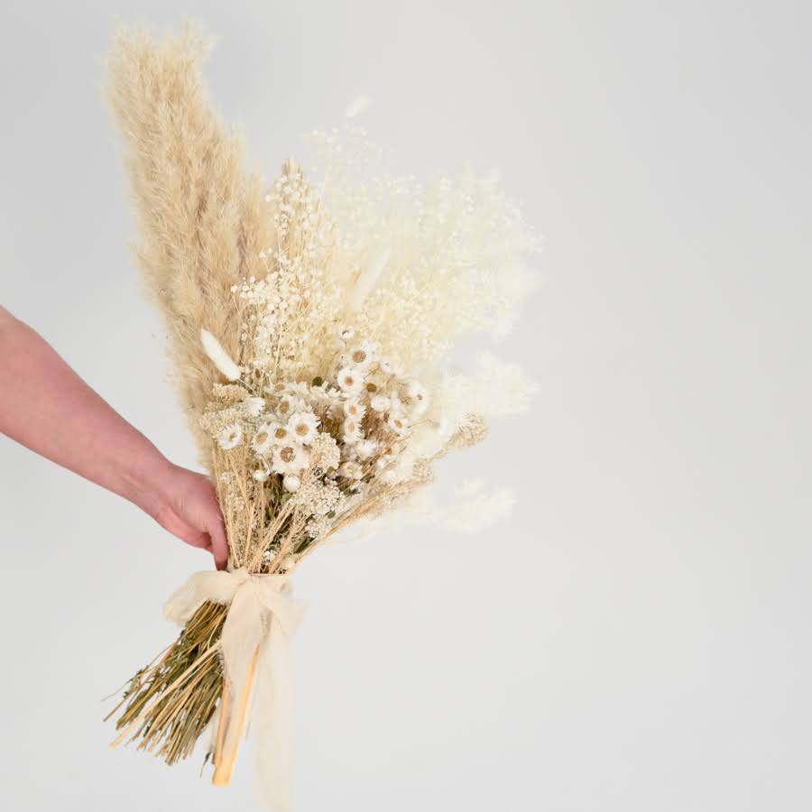 holding a bunch of wedding flowers